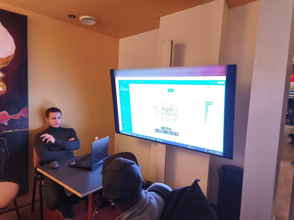Demonurk: esitleja istub sülearvuti taga, suurel ekraanil on Power BI rakendus.